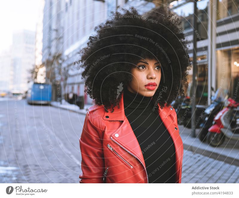 Schwarze Frau mit Afro-Haar auf der Straße Afro-Look Afroamerikaner schwarz Stil Großstadt urban Optimist Individualität krause Haare cool Freude herzlich