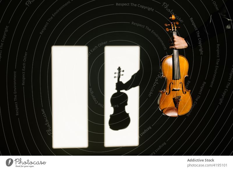 Gesichtsloser Geiger demonstriert akustische Geige in einem dunklen Raum Person Musiker Instrument manifestieren Schnur klassisch Dunkelheit Fenster Inspiration