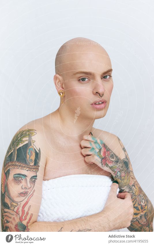 Femininer Transgender-Mann im Handtuch auf weißem Hintergrund schwul feminin Tattoo lgbt sanft sensibel Selbstachtung Angebot verträumt Porträt Schönheit