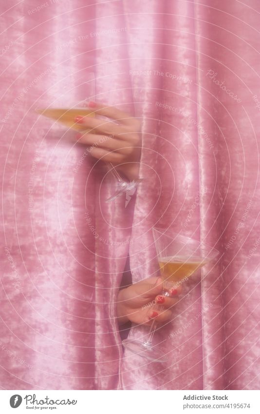 Crop Frau mit Gläsern von Champagner durch Samt Stoff Loch Glas alkoholisch trinken Getränk feiern festlich Gardine Alkohol durchsichtig Anlass Veranstaltung