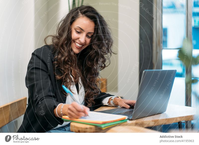Unternehmerin macht sich im Café Notizen in einem Notizbuch Geschäftsfrau zur Kenntnis nehmen Arbeit abgelegen heiter schreiben Notebook Laptop Business Frau