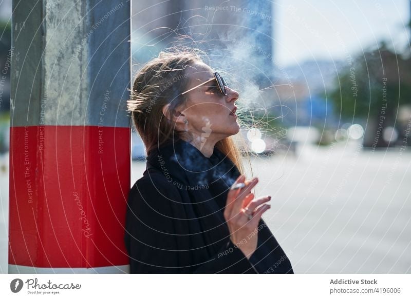 Frau raucht Zigarette in der Nähe der Stadtstraße im Sonnenlicht Rauch Hauch ausatmen Dampf Cloud genießen Straße Beitrag Verdunstung Individualität cool
