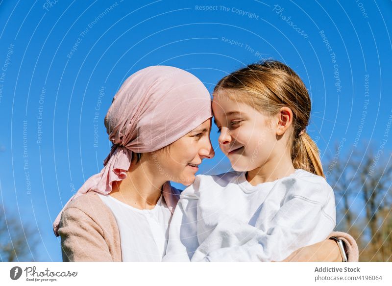 Kranke Mutter mit Tochter im Park Frau Zusammensein Krebs Liebe Partnerschaft Sommer Glück Krankheit Eltern Lächeln sich[Akk] entspannen Umarmen Konzept rosa
