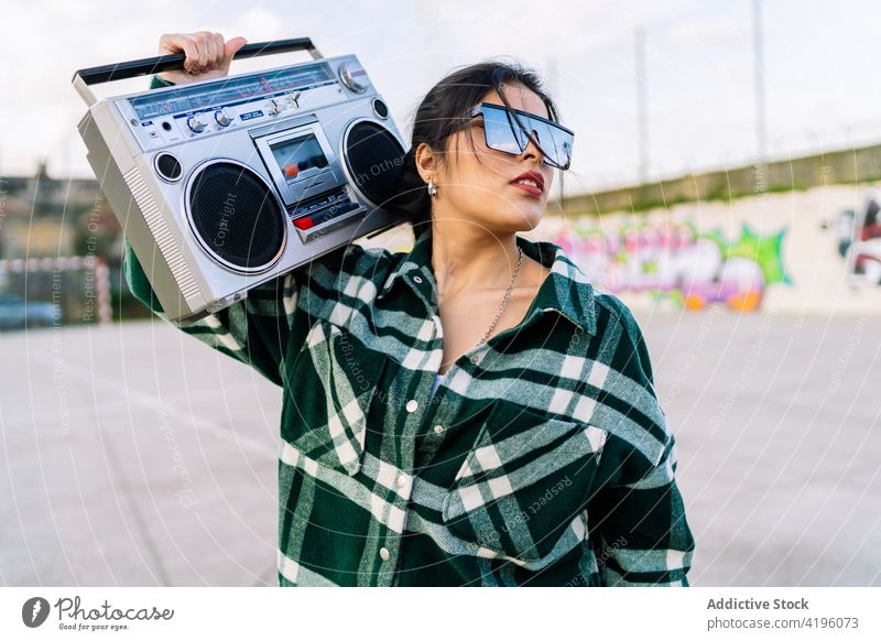Stilvolle Frau hört Musik aus einem Retro-Kassettenrekorder im Freien Schreiber Mode zuhören stylisch retro Graffiti Stadt Straßenkunst Reflexion & Spiegelung