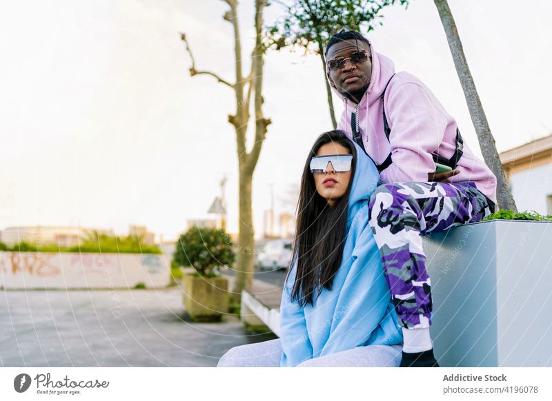 Stilvolle multirassische Freunde ruhen sich auf dem Bürgersteig in der Stadt aus Partner Mode Individualität cool Sonnenbrille kreativ Design Porträt