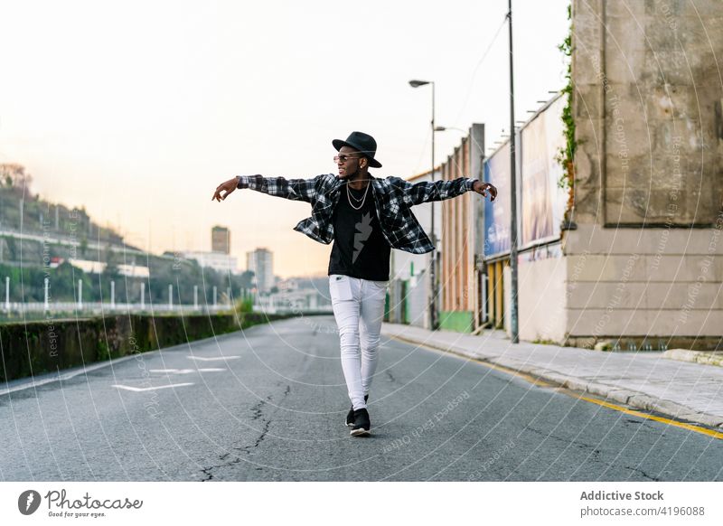 Stilvoller schwarzer Mann mit Hut auf einer Straße in der Stadt Mode Individualität cool ausdehnen maskulin Macho Afroamerikaner ethnisch Jeanshose