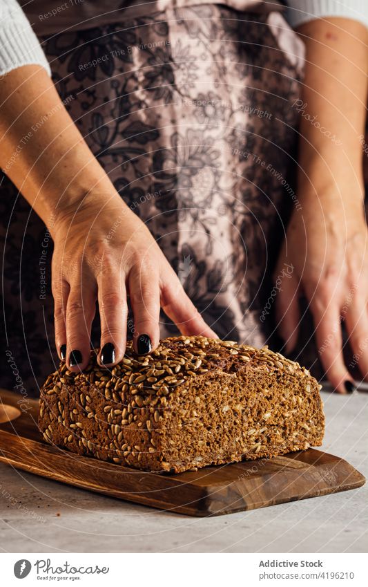 Handwerker mit Mehrkornbrot in der Bäckerei geschnitten Brot Brotlaib Nährstoff Müsli geschmackvoll Frau gebacken Kunstgewerbler sortiert Nudelholz Utensil