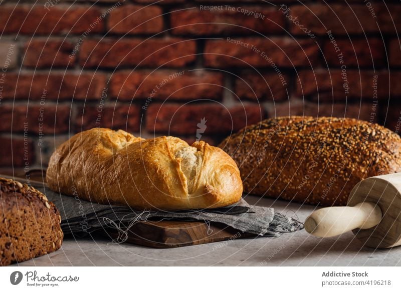 Verschiedenes Mehrkornbrot in der Bäckerei Brot Müsli gebacken Nährstoff Vitamin frisch lecker Backsteinwand Loft Stil rau weiß Roggen geschmackvoll natürlich