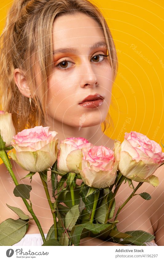 Stilvolle Frau mit rosa Rosen im Atelier stehend Roséwein Blume trendy Outfit Blüte duftig einwandfrei traumhaft sensibel schön jung attraktiv hübsch Flora