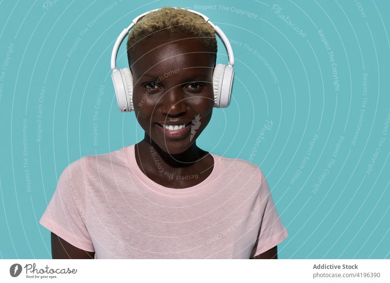 Ruhige schwarze Frau, die mit Kopfhörern Musik hört schön Afrikanisch charismatisch expressiv Audio Gerät Gesang Apparatur Amerikaner Melodie zuhören traumhaft