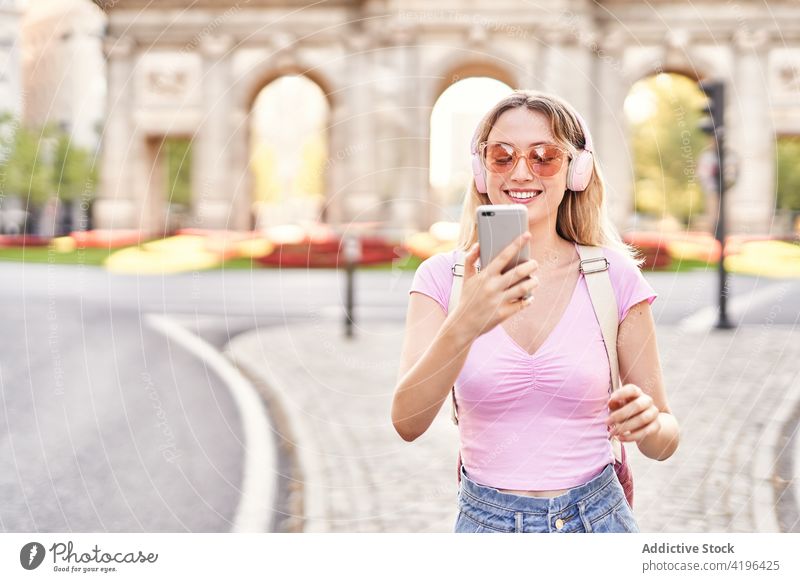 Begeisterte Teenagerin macht Selfie mit Smartphone Frau heiter benutzend Musik Kopfhörer zuhören Sightseeing Gerät Selbstportrait Sonnenbrille Telefon Optimist