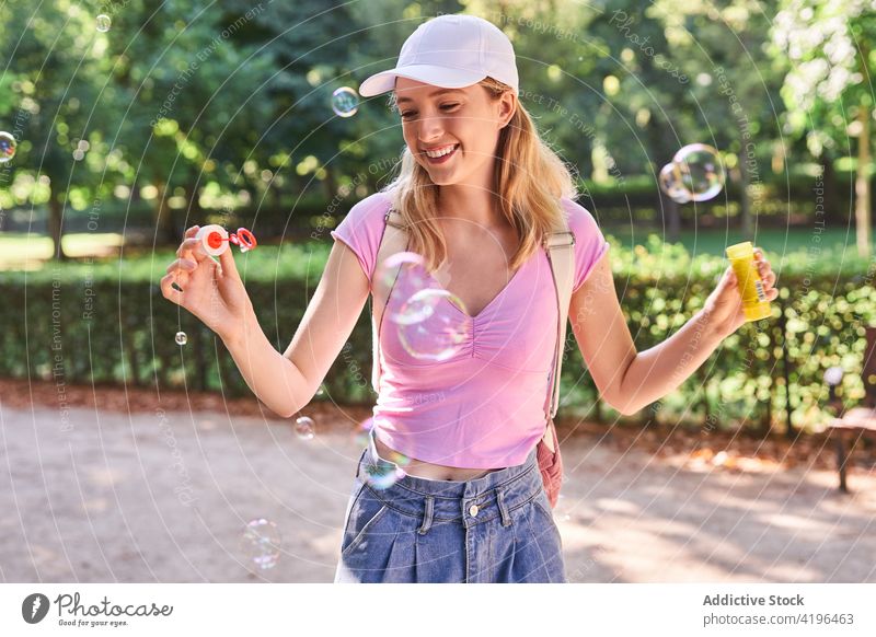Teenagerin bläst Seifenblasen im Park Frau Schlag sorgenfrei Zeitvertreib froh Spaß genießen Lächeln Optimist Jugendlicher Natur Sommer spielerisch Sonnenlicht