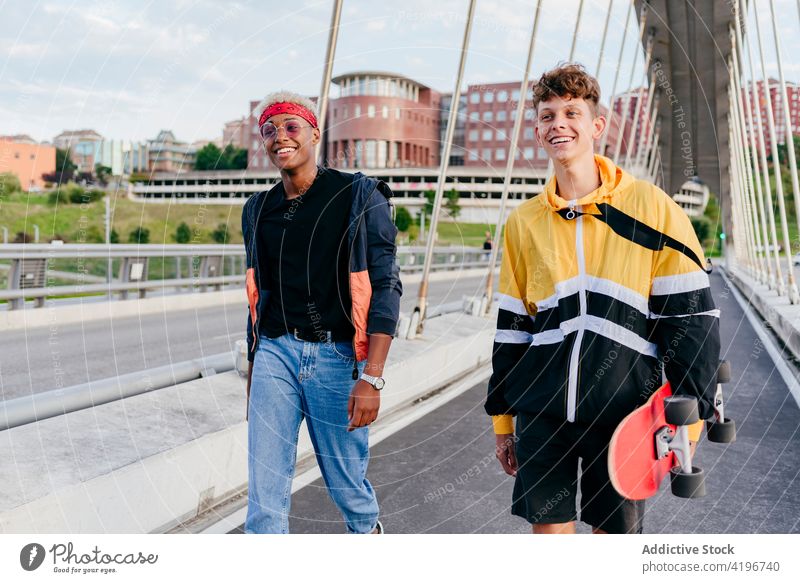 Zwei gut aussehende Teenager mit Skateboard stehen auf der Brücke Herbst schwarz Junge Kaukasier Großstadt farbenfroh Gesellschaft Tageslicht ethnisch