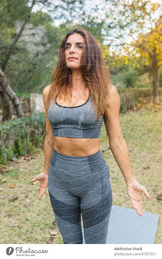 Frau beim Yoga in Bergpose Berg-Pose üben Park Zen Asana friedlich Harmonie Sportbekleidung Wohlbefinden Achtsamkeit ruhig Stressabbau tadasana Gelassenheit