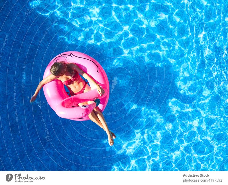 Glückliche Frau schwimmt im Schwimmbad Pool Sommer aufblasbar heiter genießen Urlaub Schwimmer sich[Akk] entspannen Feiertag Wasser schwimmen Ring rosa Resort