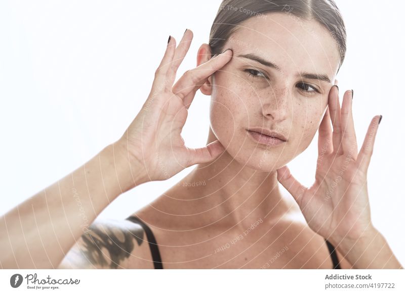 Sommersprossige Frau berührt Gesicht mit manikürter Hand Porträt Individualität sanft natürlich charmant Gesicht berühren Sommersprosse Vorschein Make-up