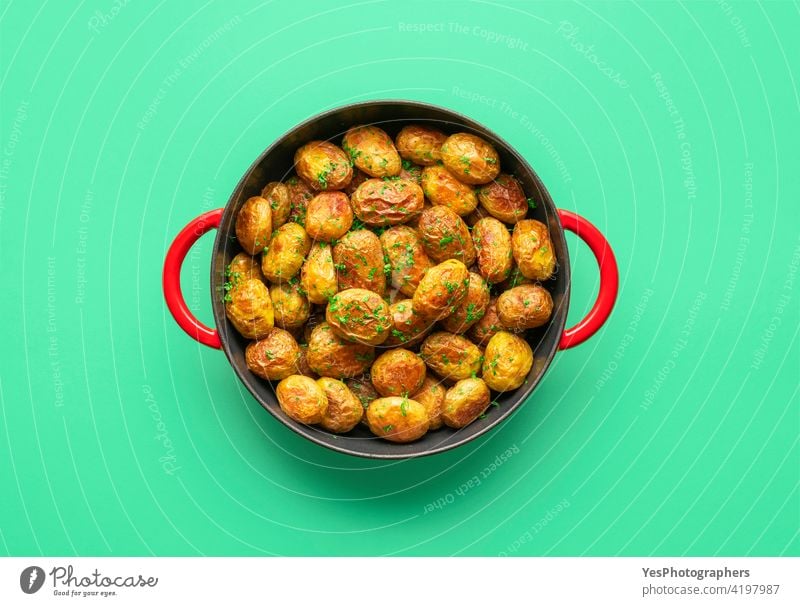Gebratene Babykartoffeln in einer Pfanne, Ansicht von oben auf grünem Hintergrund. Amuse-Gueule kleine Kartoffeln gebacken Farbe Textfreiraum Küche ausschneiden