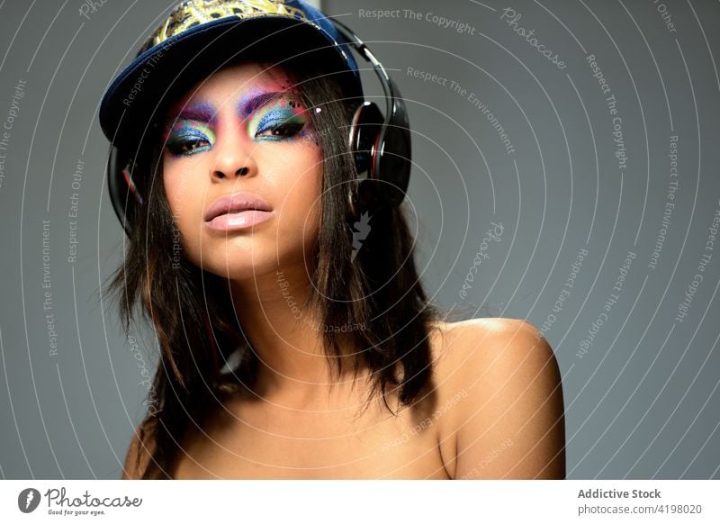 Porträt einer brünetten Frau mit langen Haaren und geschminkten Augen schön Erwachsener Atelier Gesicht Mode attraktiv Model Musik Kopfhörer jung Hintergrund
