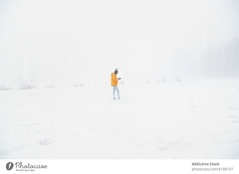Schwarzer Mann steht in verschneitem Tal im Dunst Winter kalt natürlich Umwelt Schnee weiß Tierwelt männlich Winterzeit gefroren frieren Landschaft stumm Frost