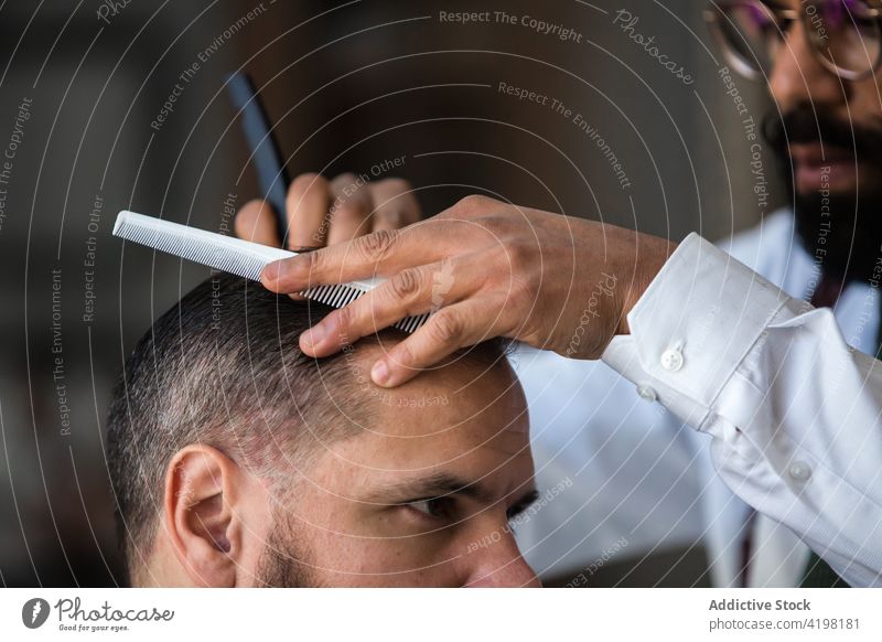 Ethnischer Barbier rasiert Kunden im Friseursalon Rasieren Klient Rasierer Behaarung Verfahren Schönheit Genauigkeit Salon Männer sanft Haarschnitt präzise