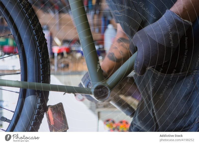 Konzentrierter Mann repariert Fahrrad in Garage Reparatur Fahrzeug Meister vorbereiten Fähigkeit Arbeitsplatz professionell männlich Rad Rand Dienst Reifen