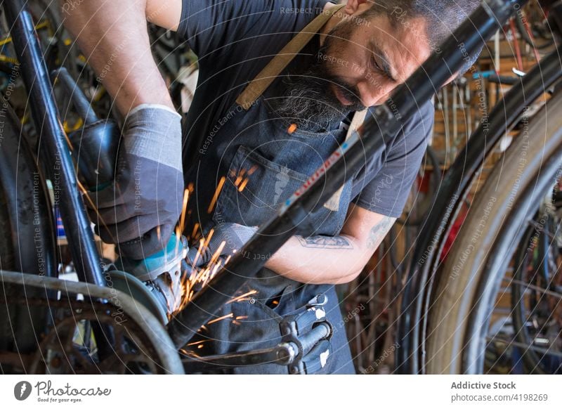 Konzentrierter Mann repariert Fahrrad in Garage Reparatur Fahrzeug Meister vorbereiten Fähigkeit Arbeitsplatz professionell männlich Rad Rand Dienst Reifen