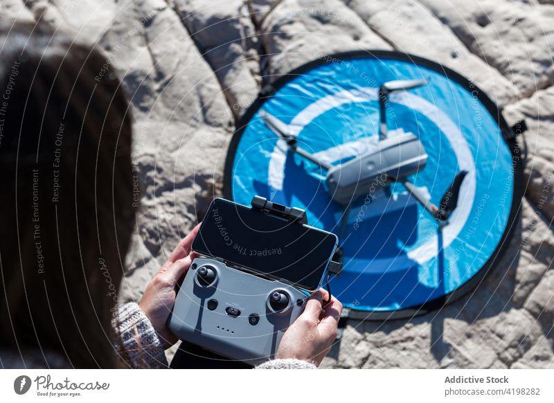 Anonyme Frau steuert Drohne in der Natur Dröhnen abgelegen Kontrolle arbeiten unbemannt Unterlage Landen Regler Strand Gerät Apparatur benutzend Hobby Sommer
