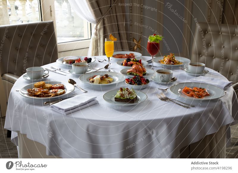 Servierter Tisch mit verschiedenen Speisen und Getränken in einem stilvollen Restaurant Tabelleneinstellung Saft Frühstück Lebensmittel Mahlzeit lecker elegant