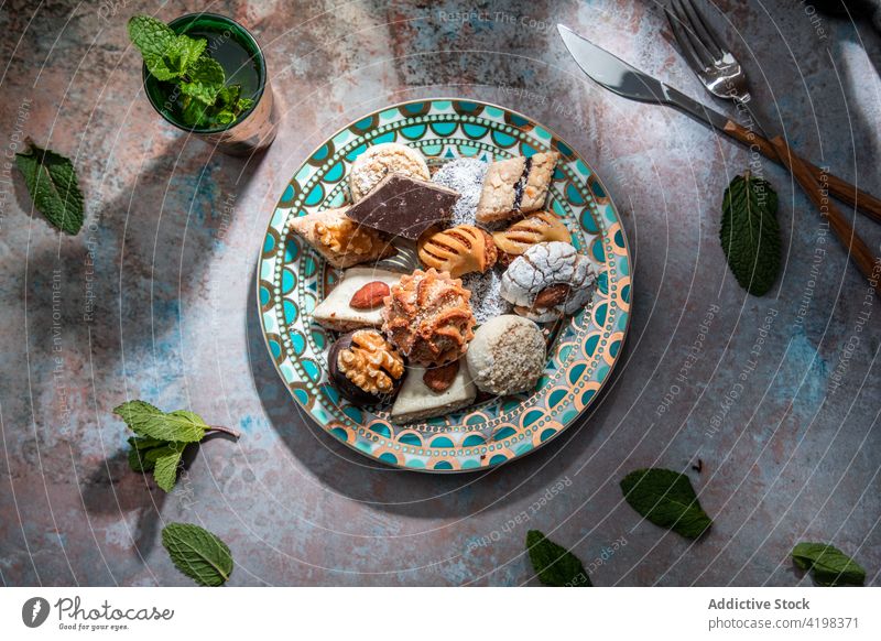 Traditionelle Süßigkeiten aus dem Nahen Osten mit Tee im Restaurant Baklava Biskuit gebacken süß Marokkanischer Pfefferminztee Messer Gabel Naher Osten anders