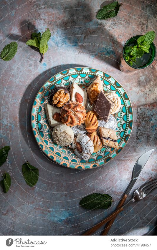 Traditionelle Süßigkeiten aus dem Nahen Osten mit Tee im Restaurant Baklava Biskuit gebacken süß Marokkanischer Pfefferminztee Messer Gabel Naher Osten anders