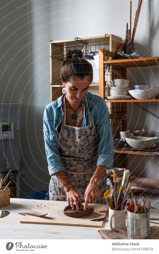 Konzentrierte Handwerkerin beim Formen von Ton in einem Kunstatelier Frau Arbeit Kunstgewerbler Werkstatt kreieren Konzentration Talent Fokus Fähigkeit