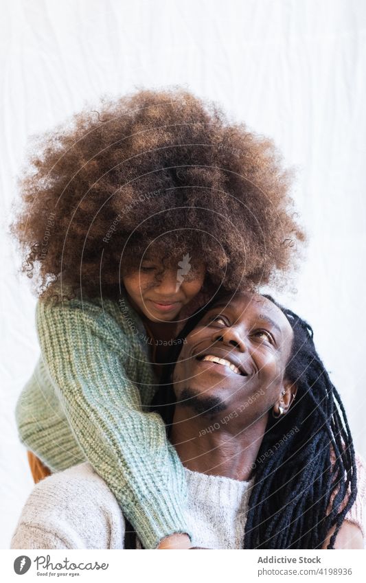 Liebevolle Tochter umarmt sanft den fröhlichen Vater Umarmen heiter Bonden schließen froh Streicheln Mädchen Papa Mann Rastalocken Kind Afro-Look genießen