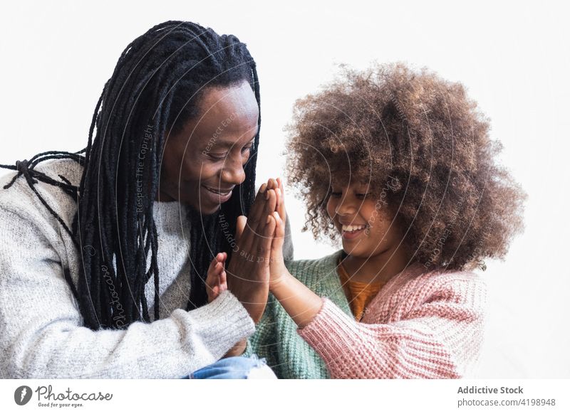 Entzückter schwarzer Mann kuschelt mit seiner Tochter Vater heiter kuscheln Streicheln angenehm sorgenfrei Bonden genießen Zusammensein Mädchen Papa Kind