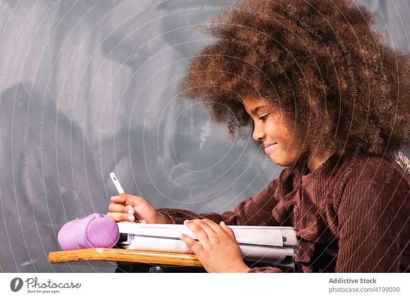 Schwarze Schülerin am Schreibtisch im Klassenzimmer Mädchen Schule Lektion Schulmädchen Teenager Tafel lernen Bildung clever ethnisch schwarz Afroamerikaner