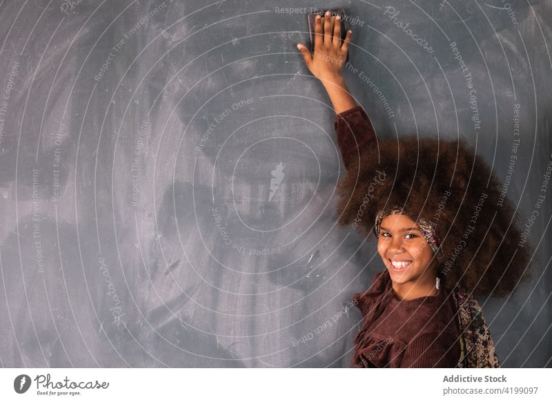 Schwarzes Mädchen schreibt auf Tafel im Klassenzimmer Pupille Beispiel lösen schreiben Lektion ethnisch Afroamerikaner schwarz Schule Schulmädchen lernen clever