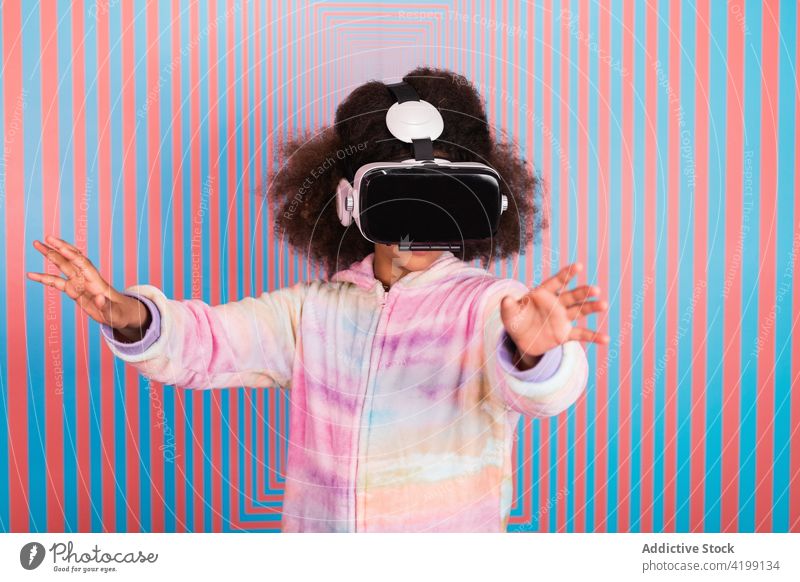 Schwarzes Mädchen benutzt VR-Brille im Studio virtuell Realität Erfahrung Teenager interagieren simulieren Schutzbrille Headset ethnisch schwarz Afroamerikaner