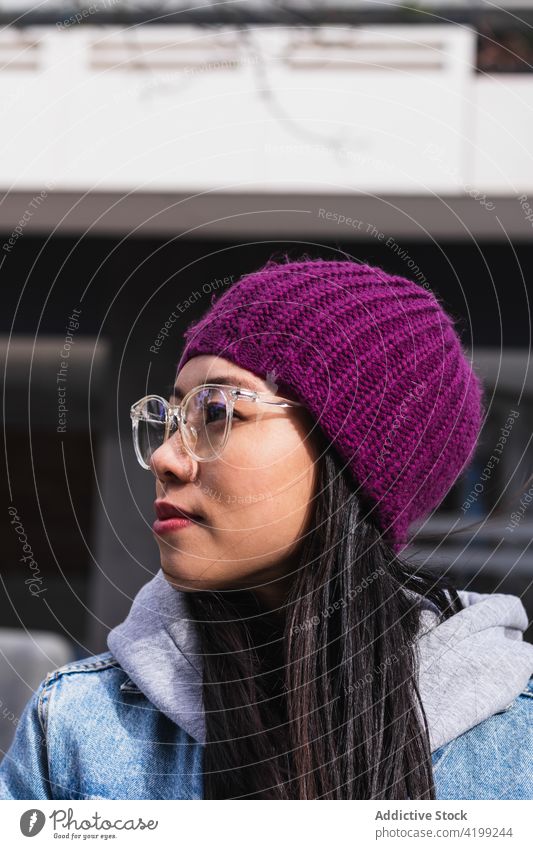 Asiatische brünette Frau mit langen Haaren lehnt an der Wand und schaut weg Japanisch asiatisch Asien jung Model Chinesisch Stil attraktiv Dame Straße modern