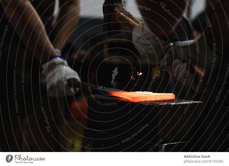 Schmied in der Werkstatt, der mit einem Hammer heißes Metall schmiedet Männer Hufschmied aufschlagen Detailaufnahme Metallbearbeitung schmieden industriell