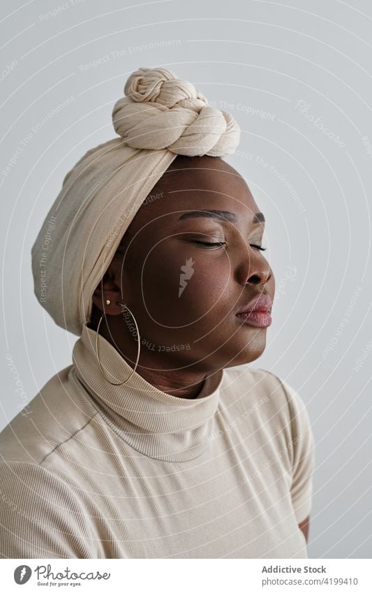 Selbstbewusste junge schwarze Dame mit Turban und geschlossenen Augen Frau Stil selbstbewusst traumhaft Model Porträt Vorschein Persönlichkeit feminin