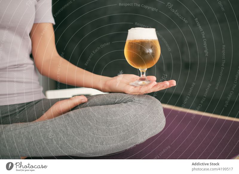 Frau beim Yoga mit einem Glas Bier zu Hause Lotus-Pose meditieren brauen padmasana Gelassenheit Mudra Unterlage sich[Akk] entspannen Wellness Windstille