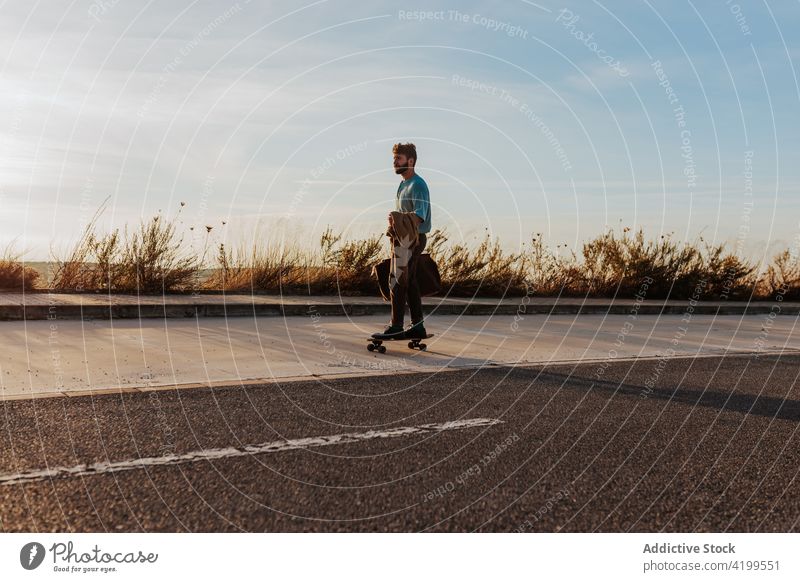 Entspannter stilvoller Skater fährt Skateboard auf dem Bürgersteig Mann Mitfahrgelegenheit Straßenbelag Freiheit sich[Akk] entspannen trendy Stil Natur ländlich