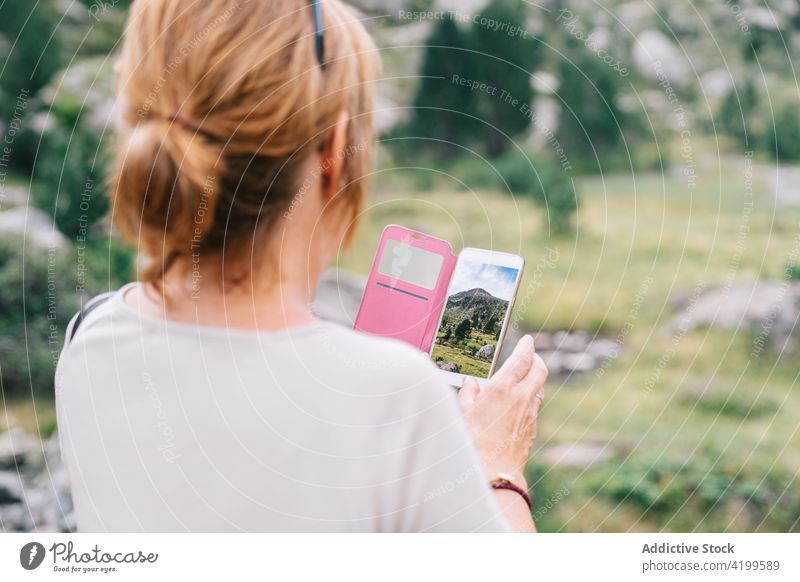 Nicht erkennbare Frau, die ein Foto von einer malerischen Berglandschaft macht fotografieren Hochland Smartphone Bergsteiger gebirgig reisen Gedächtnis