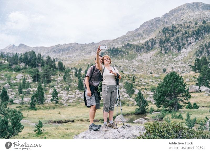Ein Paar Wanderer macht ein Selfie mit dem Smartphone vor einem Berg Gedächtnis Moment Berge u. Gebirge Hochland Natur benutzend Apparatur Selbstportrait Gerät