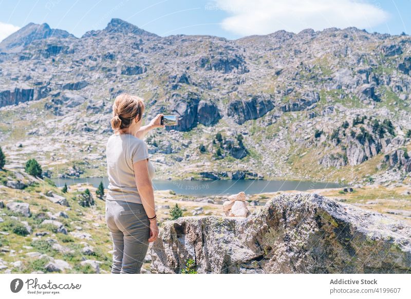Nicht erkennbare Frau, die ein Foto von einer malerischen Berglandschaft macht fotografieren Hochland Smartphone Bergsteiger reisen Gedächtnis Fotografie