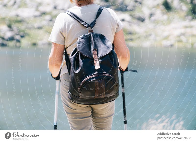 Unbekannte Frau mit Wanderstöcken am steinigen Flussufer stehend Stangengehen Mast Energie Trekking malerisch Rudatal sonnig Konzentration Katalonien strömen
