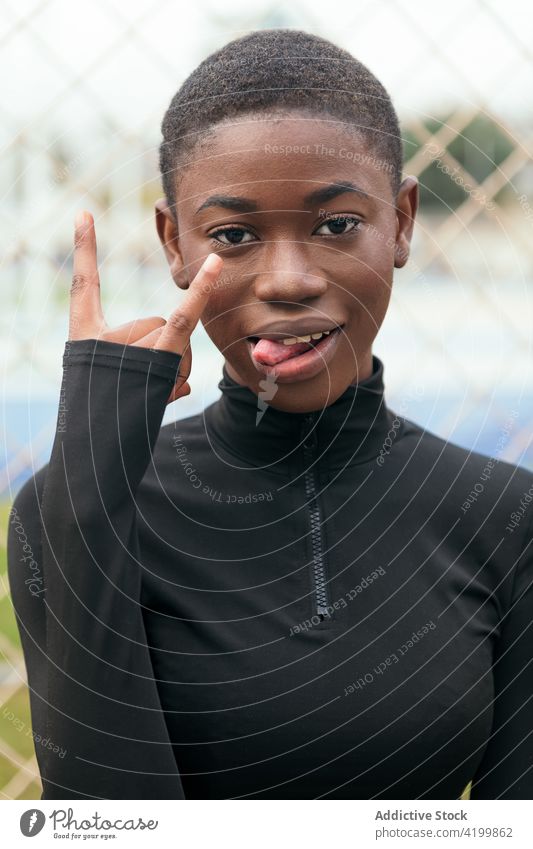 Unhöfliche schwarze Frau zeigt Mittelfinger in der Stadt ficken unverschämt auflehnen angriffslustig anstößig schlecht gestikulieren ausdehnen Lächeln Inhalt