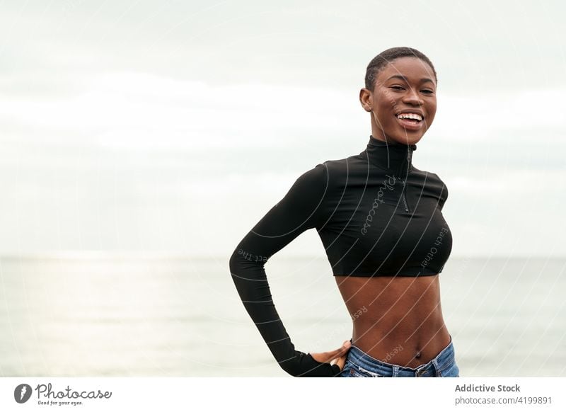 Trendiges schwarzes Modell am Meeresufer Frau Kurze Haare Stil sensibel Bauch sanft Porträt trendy Angebot romantisch feminin herzlich Afroamerikaner Küste