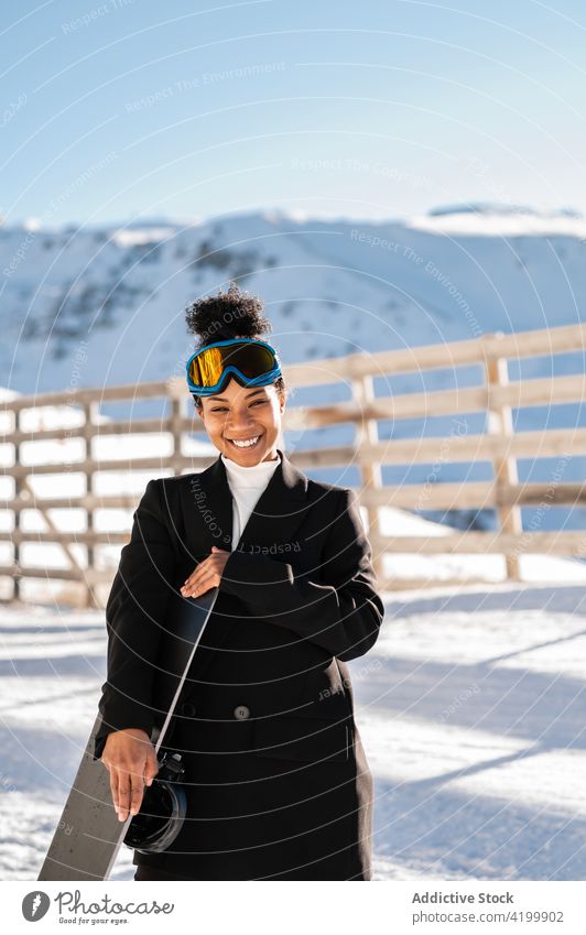 Inhalt schwarzer Sportler mit Snowboard in verschneiten Bergen Athlet Resort Stil Glück Berge u. Gebirge Natur Schnee Winterzeit Frau Reittier Hochland Zaun
