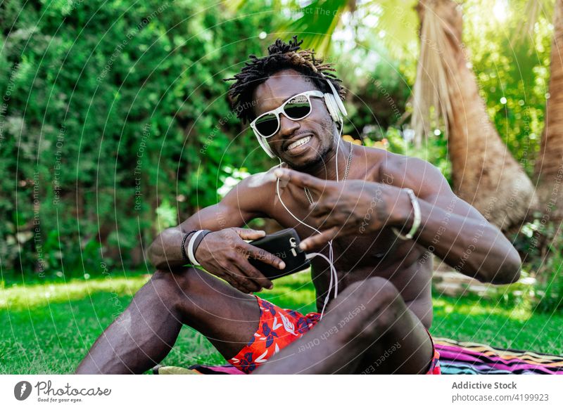 Cooler schwarzer Mann zeigt Rock-Geste Felsen gestikulieren zuhören Musik unter Kopfhörer Selfie Rock and Roll Hupe Lächeln cool männlich ethnisch
