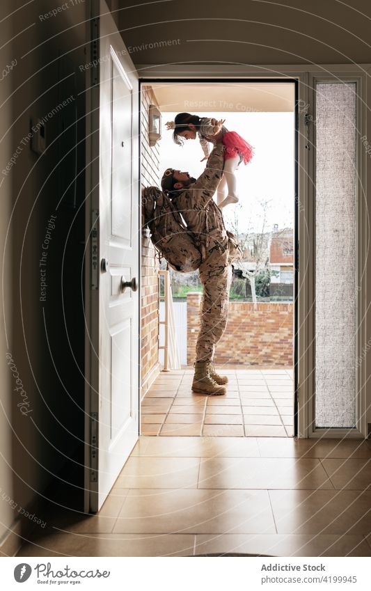 Militärischer Vater spielt mit Tochter spielen Kind Soldat Heimkehr werfen Zusammensein Mann männlich Mädchen Türöffnung Haus Partnerschaft Uniform Rucksack